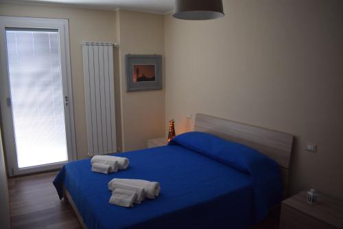 Un dormitorio con una cama azul con toallas. en La Dimora di Lalla en Lanciano