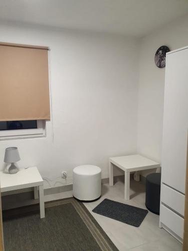 a white room with two tables and a tv at Zakątek w Zaciszu in Ustka