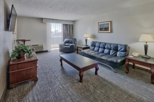 a living room with a couch and a table at Ramada by Wyndham Albuquerque Midtown in Albuquerque