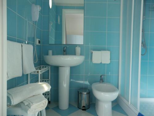 a blue bathroom with a sink and a toilet at Mediterraneo Mare e Sole in Marina di Palma