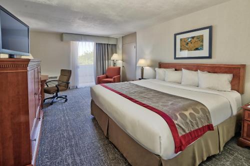 a hotel room with a large bed and a television at Ramada by Wyndham Albuquerque Midtown in Albuquerque