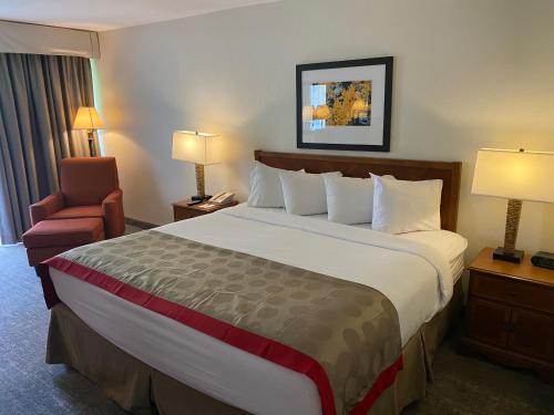 a hotel room with a large bed and a chair at Ramada by Wyndham Albuquerque Midtown in Albuquerque