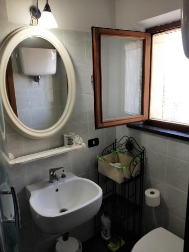 a bathroom with a sink and a mirror and a toilet at Central Lovely House in Montepulciano