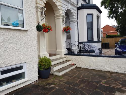 a white house with a blue door and windows at Fairhaven Guest Accommodation in Nottingham