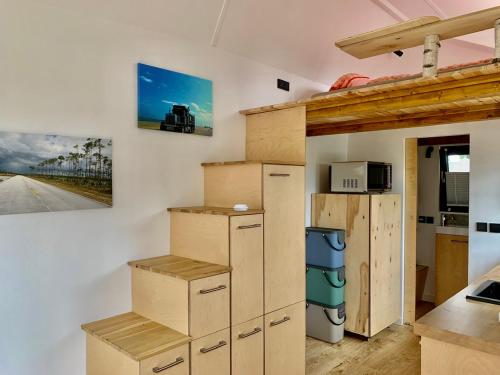 een kamer met dozen aan de muur en een keuken bij Tiny House Geierlay in Mittelstrimmig