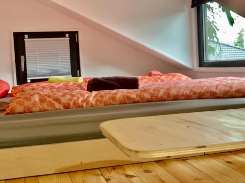 a bed sitting in a room with a wooden floor at Tiny House Geierlay in Mittelstrimmig