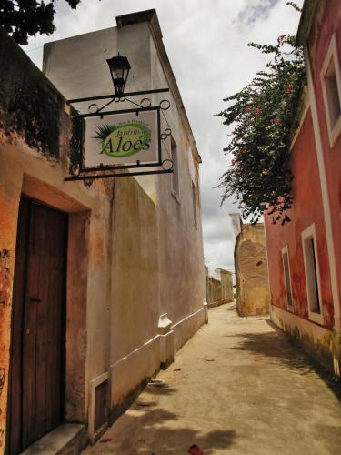 an alley with a sign on the side of a building at Jardim dos Aloés, Unique B&B - Casa de Charme in Ilha de Moçambique