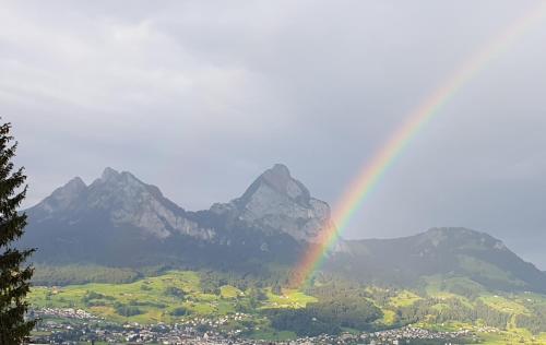 a rainbow over a city with mountains in the background at Ferienwohnung Seesicht in Brunnen