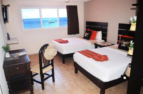 A bed or beds in a room at Hacienda Morelos Beachfront Hotel