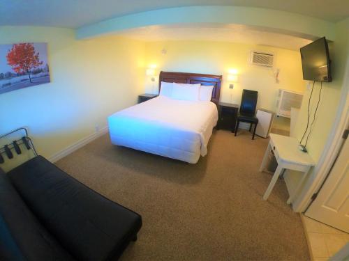 a bedroom with a white bed and a desk and a chair at Waterview On The Bay in Wiarton