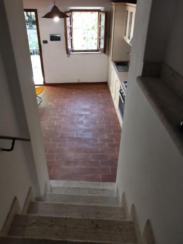 a hallway with stairs leading to a kitchen with a window at Central Lovely House in Montepulciano