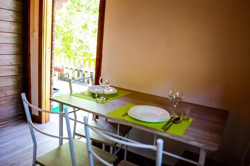 a table with two chairs and a table and glasses at Bungalow "A Choupana" - Quinta da Carvoíça - Vale Pradinhos in Vale de Pradinhos