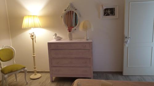 a bedroom with a dresser with a mirror and a lamp at CasAlbina in Mezzana