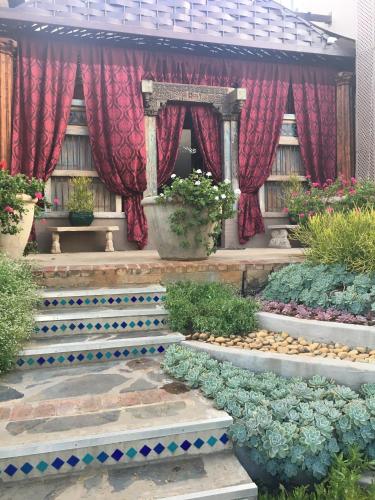 a garden with stairs and plants and red curtains at 40 on Aspen in Centurion