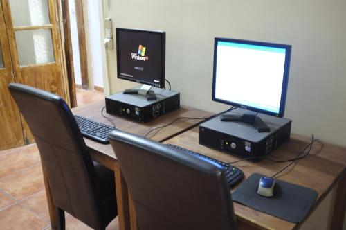 uma secretária com dois monitores e um computador em Hostal Europa em Barcelona