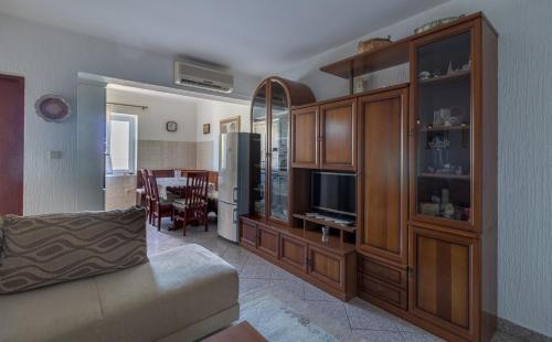 een woonkamer met een bank en een entertainmentcentrum bij Apartment Dony - Tičić in Novalja