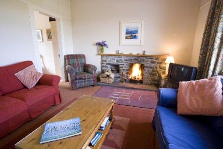 a living room with a couch and a fireplace at Caberfeidh Cottage in Bruichladdich