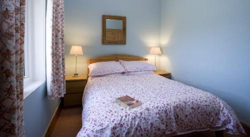 sypialnia z łóżkiem z książką w obiekcie Caberfeidh Cottage w mieście Bruichladdich