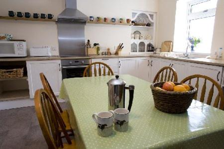 una cocina con una mesa con una cesta de fruta. en Caberfeidh Cottage, en Bruichladdich