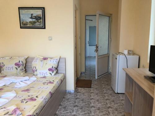 a small room with a bed and a refrigerator at Guest Rooms Nia Elis Kiten in Burgas City
