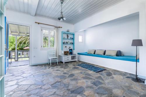 Un dormitorio con una cama azul y una ventana en Myrto Holiday House, en Stafylos