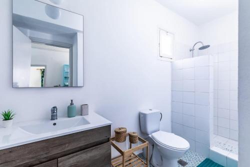 Un baño con lavabo, inodoro y espejo. en Myrto Holiday House, en Stafylos