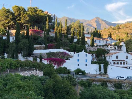 a village with trees and buildings and a mountain at La Casa Turquesa-Original in Frigiliana