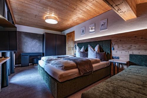 a bedroom with a large bed and a television at Alpin View in Zellberg