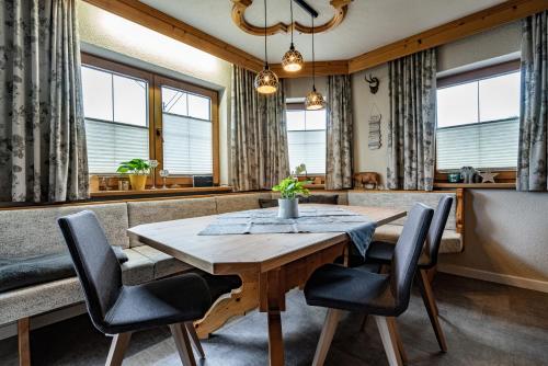 a dining room with a wooden table and chairs at Alpin View in Zellberg