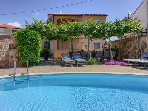 a swimming pool in front of a house at Spacious Holiday Home in Peroj with Private Pool in Peroj