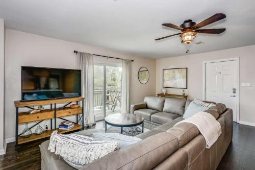 a living room with a couch and a flat screen tv at Lone Palm on the Bayou in Pensacola