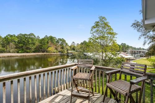 two chairs and a table on a deck overlooking a river at Lone Palm on the Bayou in Pensacola