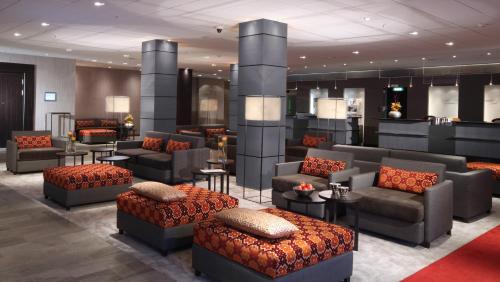 a lobby with couches and chairs in a building at Lindner Hotel Frankfurt Hochst, part of JdV by Hyatt in Frankfurt/Main