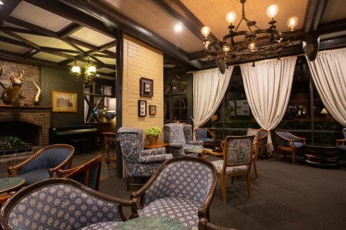 a room with chairs and tables and a chandelier at New England Motor Lodge in Glen Innes