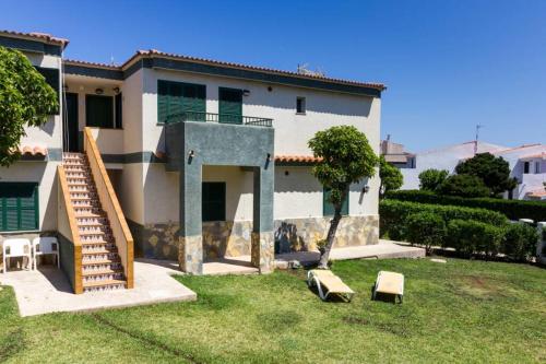 a house with a staircase in front of it at TRANQUILO APARTAMENTO con preciosa cala en la puerta in Ciutadella