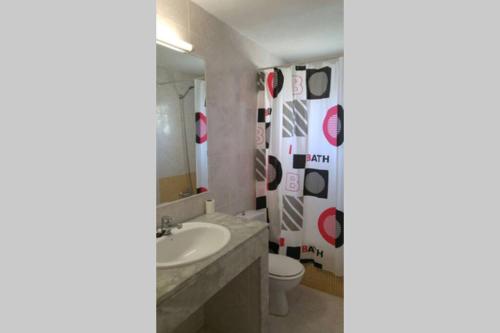 a bathroom with a sink and a toilet and a mirror at TRANQUILO APARTAMENTO con preciosa cala en la puerta in Ciutadella
