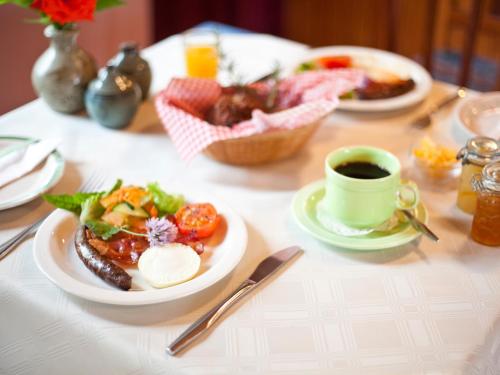 a table with a plate of food and a cup of coffee at Andelomi Forest Lodge in Stormsrivier