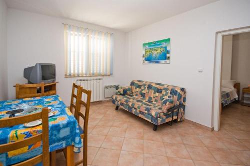 a living room with a couch and a chair at Apartments Valentino in Vrsar