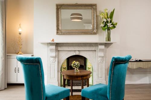 a living room with two blue chairs and a fireplace at No 9 Rathgar in Rathgar