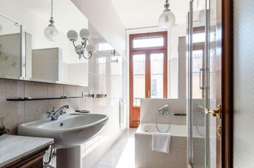 bagno bianco con lavandino e doccia di Easy Central Apartment - Milano Porta Romana a Milano