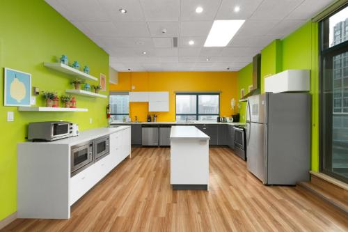 a kitchen with yellow and green walls at GEC Granville Suites Downtown in Vancouver