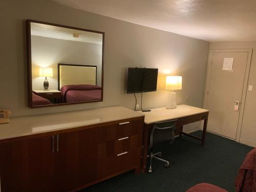 um quarto de hotel com uma secretária e um espelho em St. Mary’s Motel 