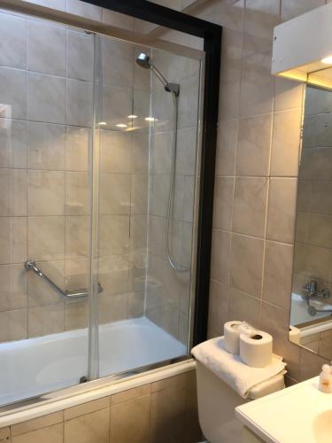 y baño con ducha, aseo y lavamanos. en Matic Apartments en Punta Arenas