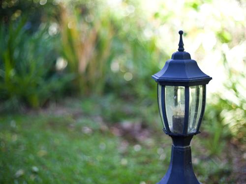 a blue lamp post in a garden with a yard at Andelomi Forest Lodge in Stormsrivier