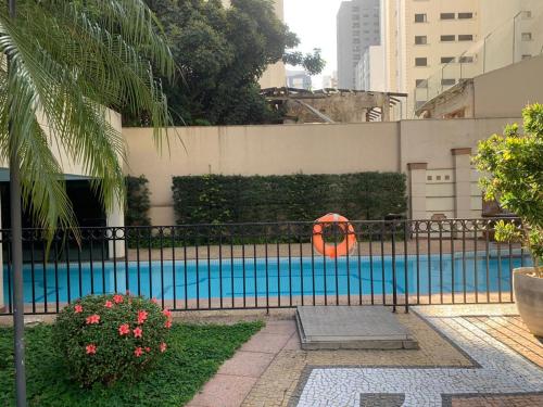 a fence with a swimming pool in a city at Residencial Luxo Moema - Macuco in Sao Paulo