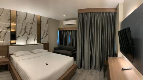 a bedroom with a bed and a desk and a chair at The chess hotel in Rayong