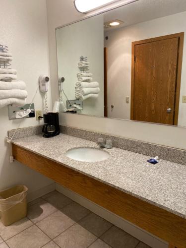 a bathroom with a sink and a large mirror at Americas Best Value Inn Champaign in Champaign