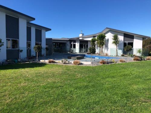 a house with a yard and a swimming pool at Wilsons Retreat - Hosts On-site in Eskdale