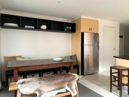 a kitchen with a table and a stainless steel refrigerator at Reindeer 6 in Mount Buller