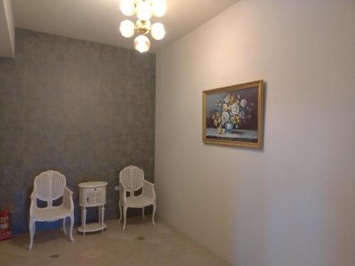 a room with three chairs and a painting on the wall at 蓋雅之都民宿 in Taitung City
